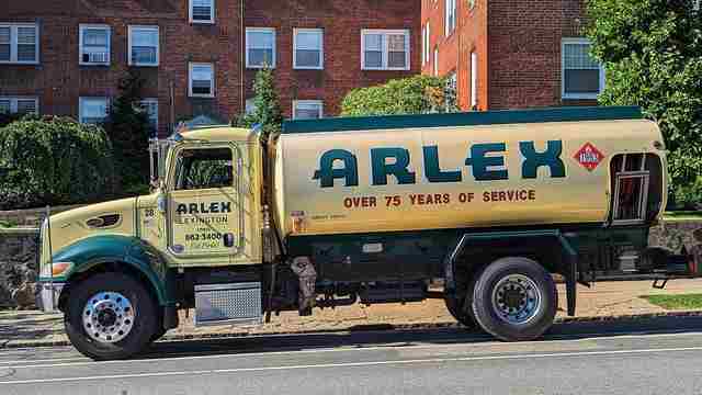 Yellow and green Arlex heating oil delivery truck on a street in Arlington, Massachusetts