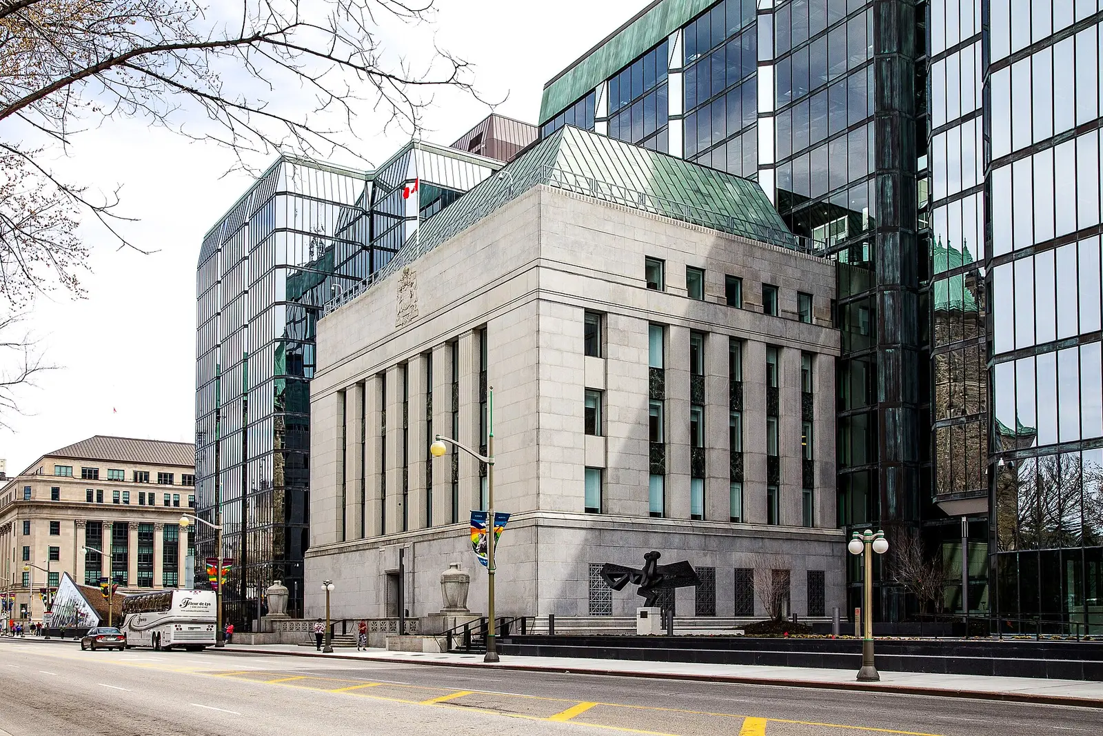 The Bank of Canada head office in Ottawa, a stone complex between glass towers, with the Canadian flag above the roof.