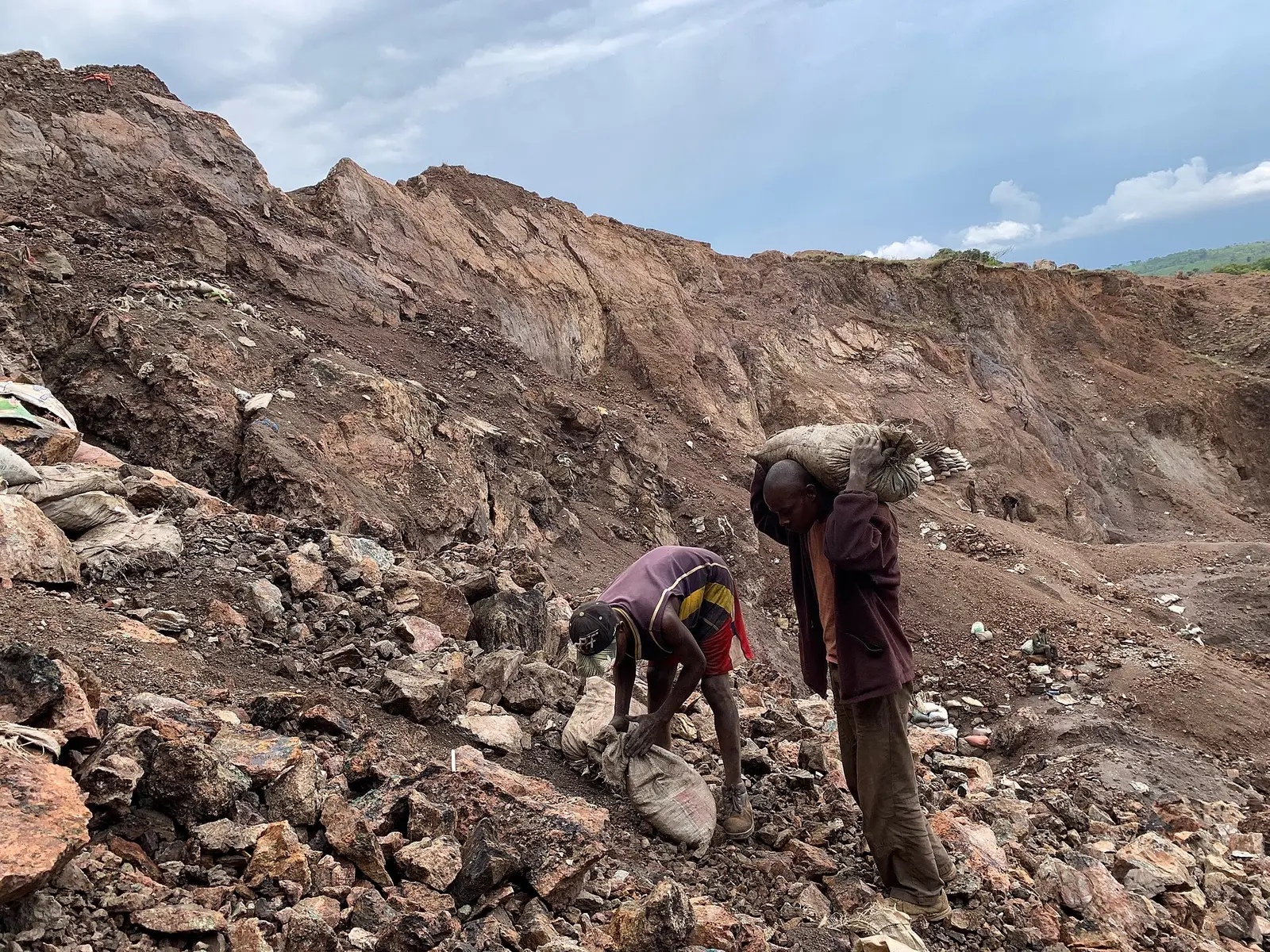 Artisanal miners with sacks of ore in an open cobalt pit near Kolwezi, Democratic Republic of Congo