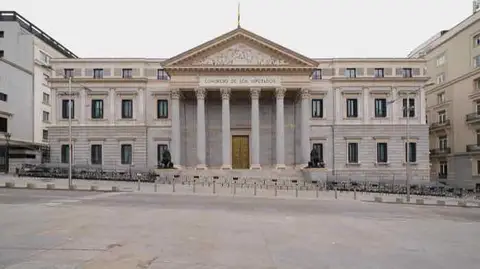 Exterior of the Congress of Deputies in Madrid, with the neoclassical portico, bronze lions and the Spanish flag