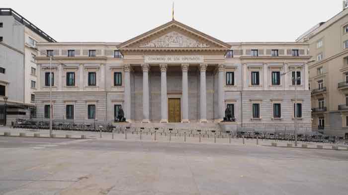 Exterior of the Congress of Deputies in Madrid, with the neoclassical portico, bronze lions and the Spanish flag