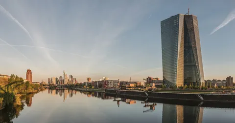 The Seat of the European Central Bank on the river Main at dawn, with the Frankfurt banking skyline behind it