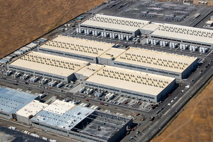 Aerial view of an Amazon Web Services availability zone showing three completed data centre halls a power substation and a fourth hall under construction