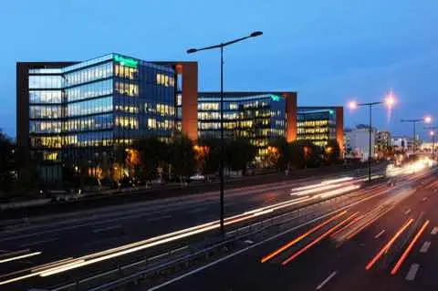 Schneider Electric headquarters at night, a glass office building beside a road