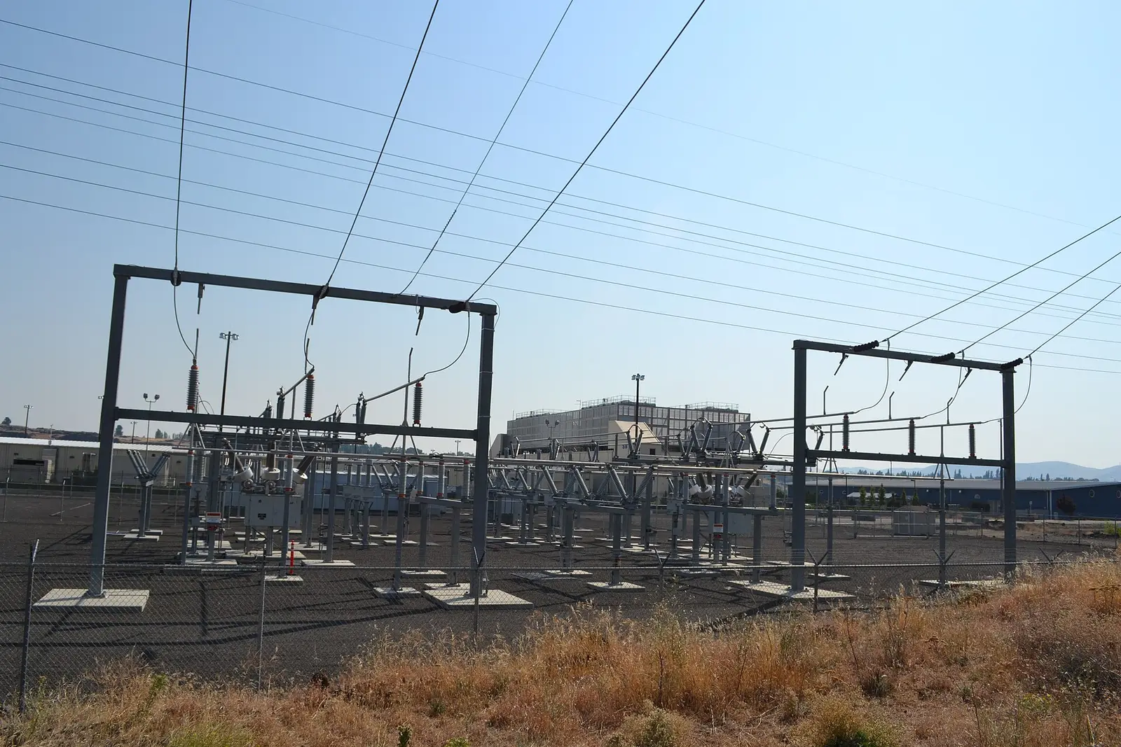 Electrical substation and transmission structures in front of a data-center building