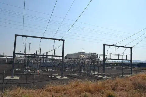 Electrical substation and transmission structures in front of a data-center building