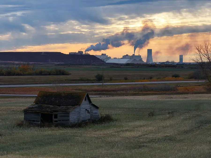Nutrien Lanigan potash mine in Saskatchewan at dusk, with the mill and a tailings pile beyond prairie fields