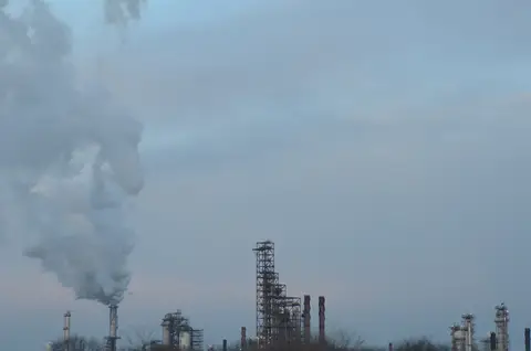 ExxonMobil refinery next to Interstate 55 near Joliet, Illinois, with a steam plume over the process units