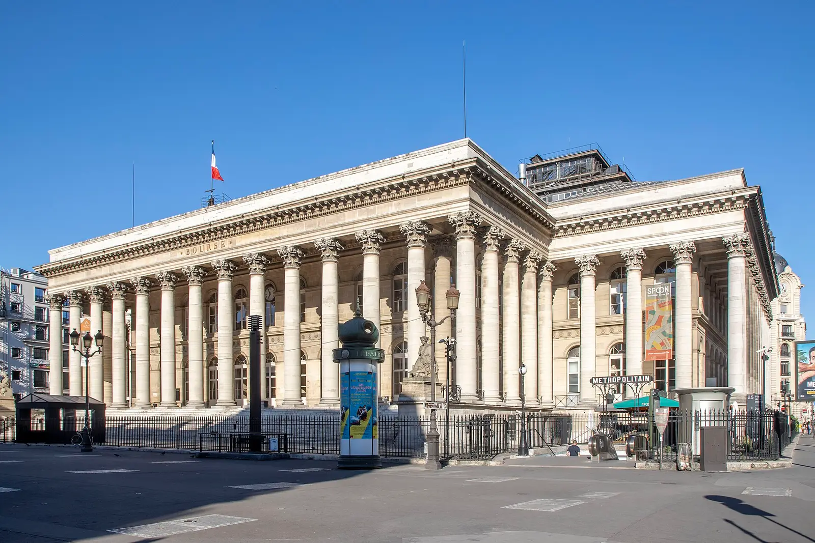 Palais Brongniart, the former Paris stock exchange building, on a sunny day with the French flag on its roof