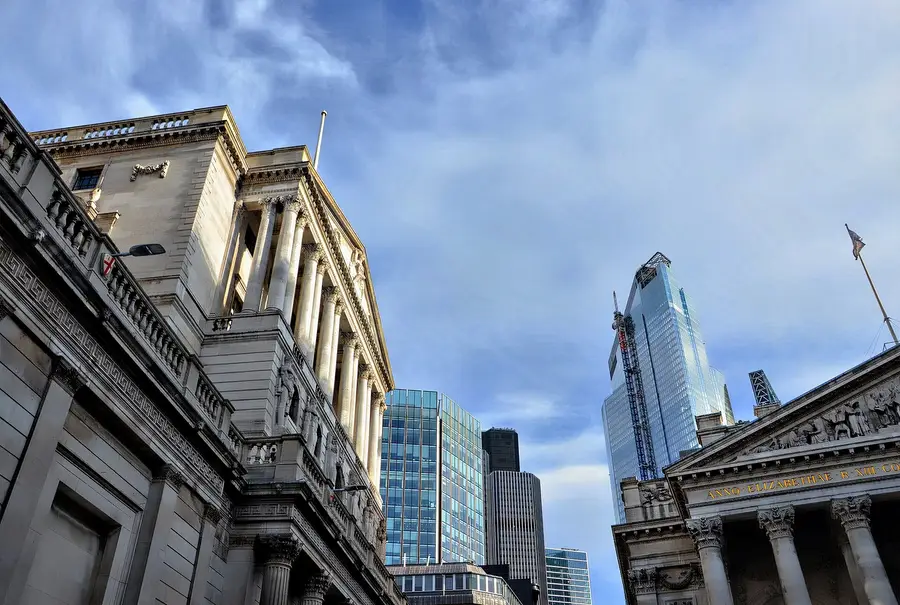 The Bank of England facade on Threadneedle Street in the City of London, with the Royal Exchange portico at right and City towers behind