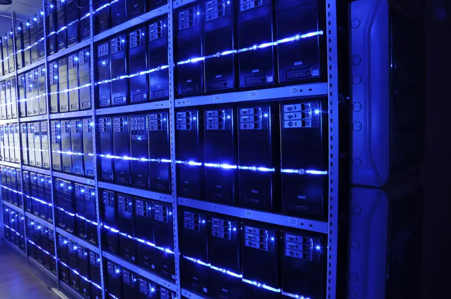 Rows of lit server towers on steel shelving inside a data centre, the kind of hardware that runs blockchain validator nodes