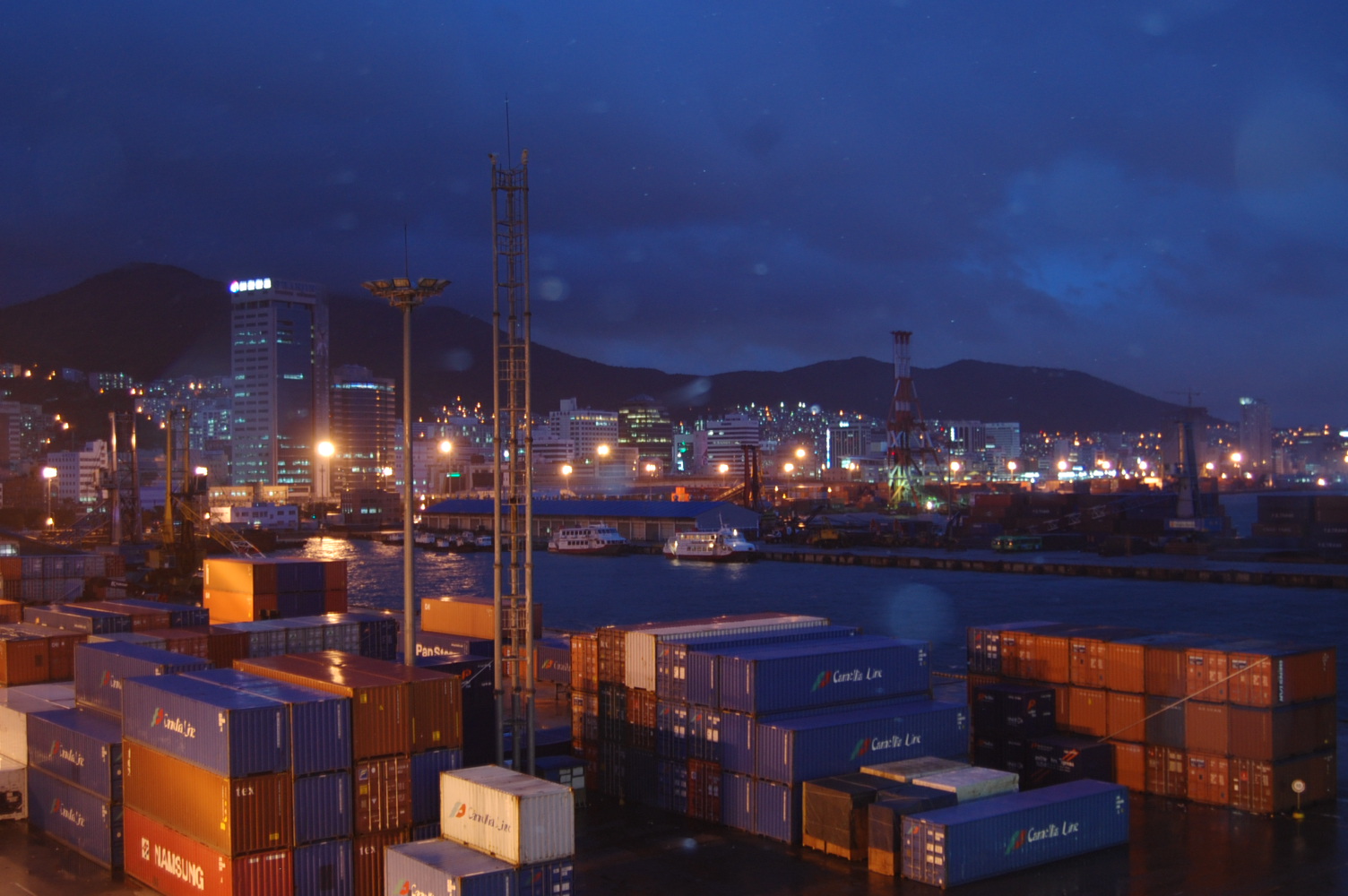 Stacked shipping containers at the Busan harbour cargo terminal in South Korea at dusk