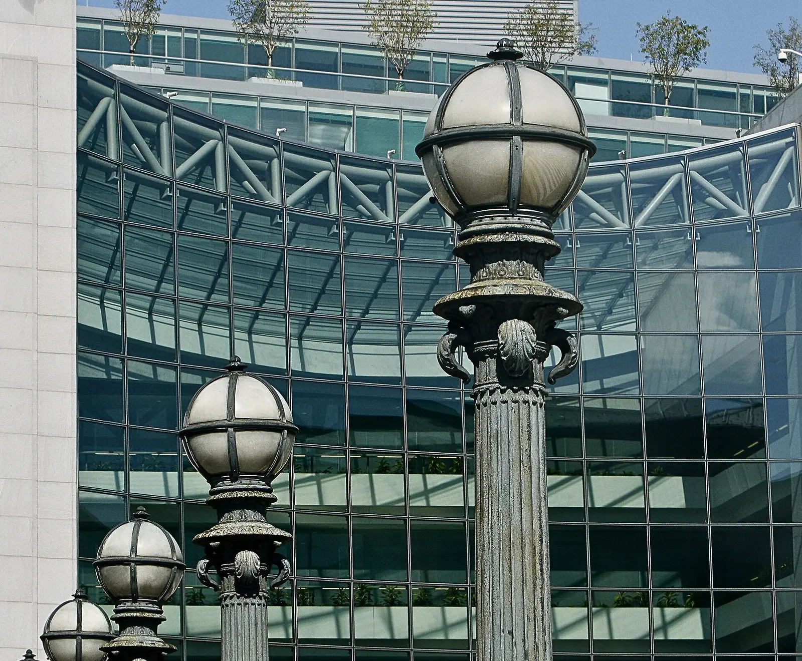 Glass facade of the U.S. Securities and Exchange Commission headquarters at 100 F Street NE in Washington D.C. seen behind period street lamps