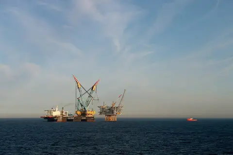 The Ivar Aasen platform deck being installed in the Norwegian North Sea by the Saipem 7000 crane vessel, with a supply ship alongside