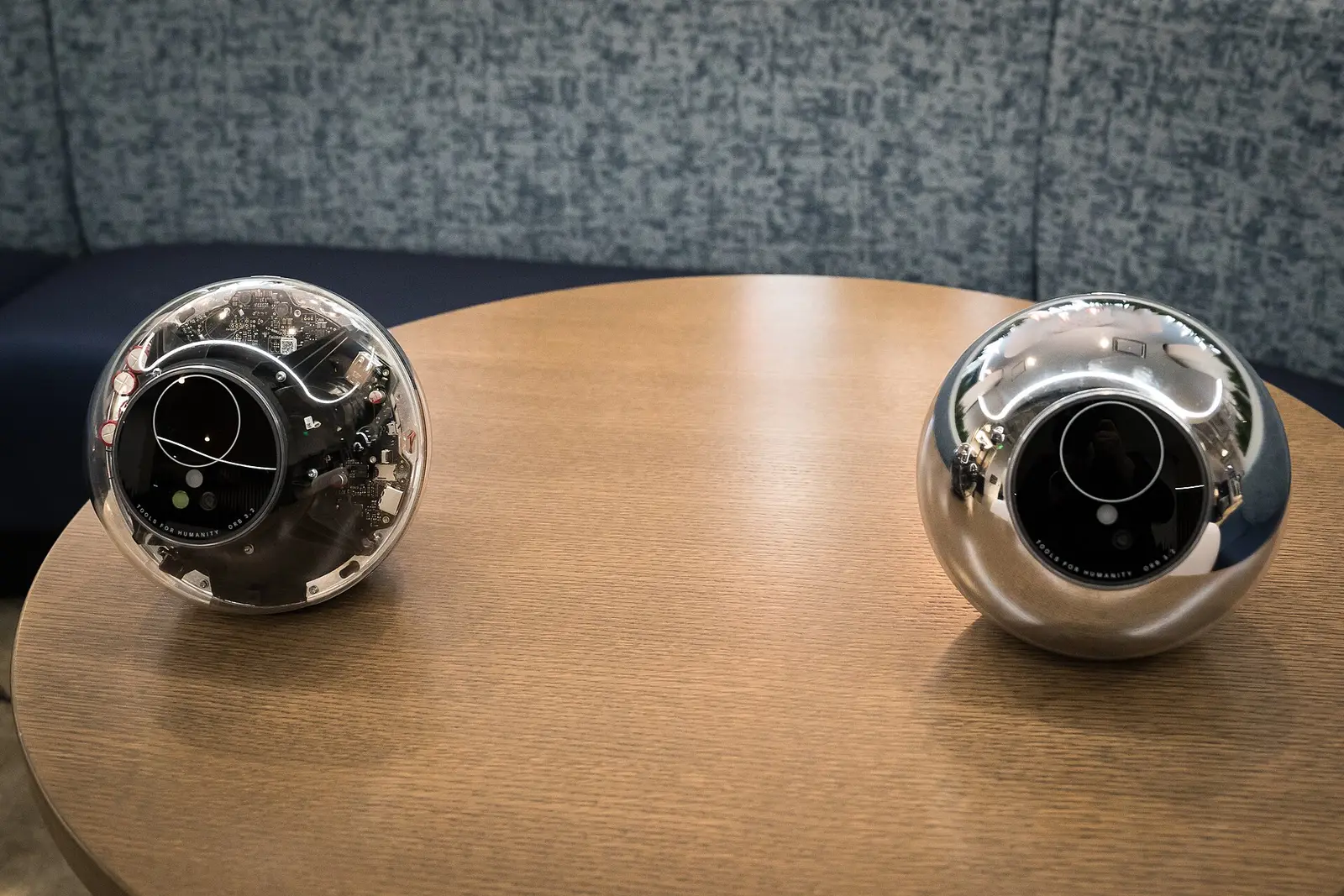 Two Tools for Humanity Orbs, one clear-cased and one chrome, on a table at a TechCrunch event in January 2024.